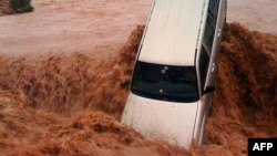A car is carried away by flood waters in the southern region of Ouarzazate in Morocco, Nov. 22, 2014.