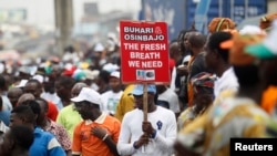 A man holds a placard campaigning for All Progressives Congress (APC) Presidential and vice Presidential candidates Muhammadu Buhari and Yemi Osinbajo during a street procession 'March for Change' in Lagos March 7, 2015. REUTERS/Akintunde Akinleye (NIGE