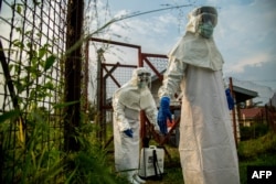 FILE - Medical staff are sterilized before entering the isolation unit at a hospital in Bundibugyo, western Uganda, on Aug. 17, 2018, where there is one suspected case of Ebola.