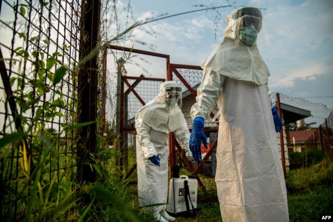 FILE - Medical staff are sterilized before entering the isolation unit at a hospital in Bundibugyo, western Uganda, on Aug. 17, 2018, where there is one suspected case of Ebola.