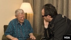 Doc Watson talks to Elvis Costello at MerleFest in 2007 (VOA/Katherine Cole)