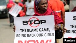 A woman carries a sign as she attends a protest demanding the release of abducted secondary school girls in the remote village of Chibok in Lagos, May 9, 2014.