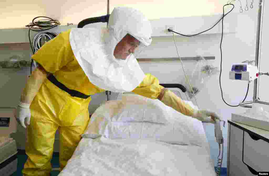 Infection control nurse Heinz Schuhmacher wears a protective suit during a media presentation at an isolation ward for possible Ebola patients at of the Universitaetsspital Basel hospital in Basel, Switzerland, Oct. 15, 2014. 