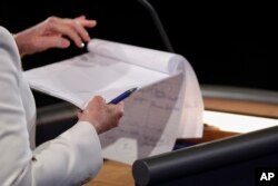 Democratic presidential nominee Hillary Clinton takes notes during the third presidential debate at UNLV in Las Vegas, Oct. 19, 2016.