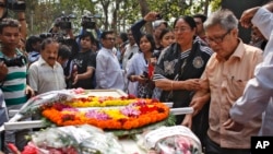 Father Ajay Roy, right, stands beside the coffin of Avijit Roy, a prominent Bangladeshi-American blogger in Dhaka, Bangladesh, March 1, 2015.