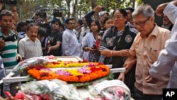 Father Ajay Roy, right, stands beside the coffin of Avijit Roy, a prominent Bangladeshi-American blogger in Dhaka, Bangladesh, March 1, 2015.