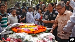 Father Ajay Roy, right, stands beside the coffin of Avijit Roy, a prominent Bangladeshi-American blogger in Dhaka, Bangladesh, March 1, 2015.