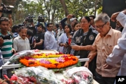 FILE - Father Ajay Roy, right, stands beside the coffin of Avijit Roy, a prominent Bangladeshi-American blogger in Dhaka, Bangladesh, March 1, 2015.