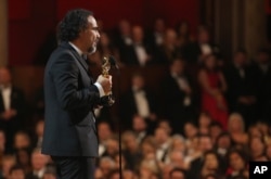 Alejandro G. Inarritu is seen from backstage as he accepts the award for best director for “The Revenant” at the Oscars, Feb. 28, 2016, at the Dolby Theatre in Los Angeles.