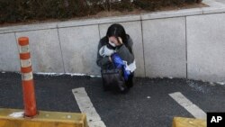 A fan weeps during the funeral of late South Korean singer Kim Jong-hyun, better known by the stage name Jonghyun, a member of South Korean K-pop group SHINee, at a hospital in Seoul, South Korea, Thursday, Dec. 21, 2017.