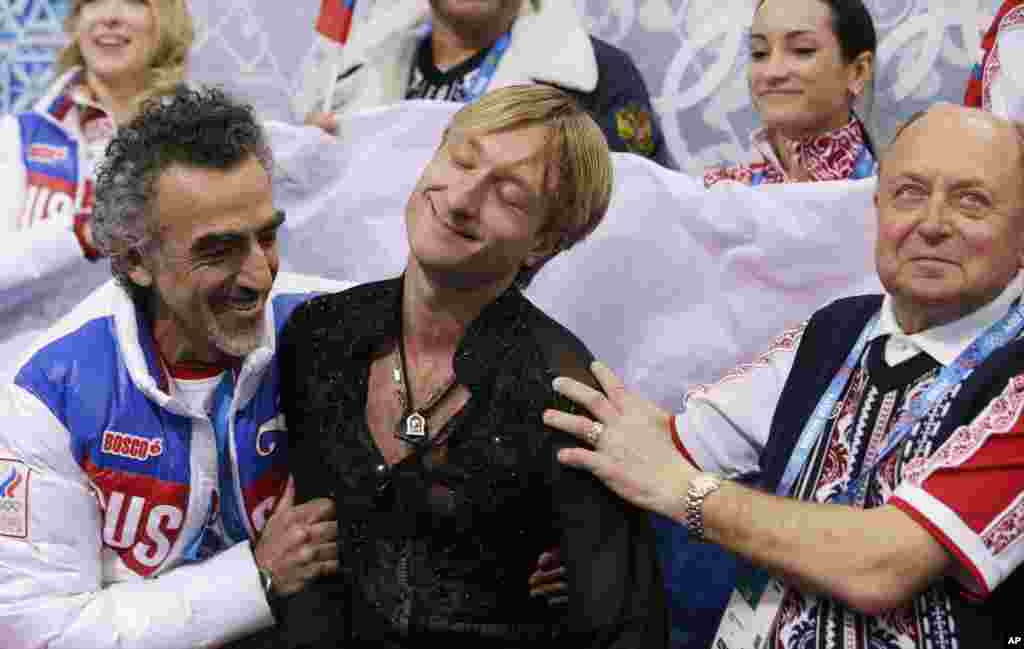 O patinador Evgeni Plushenko da Rússia, ao centro, reage depois da sua performance no pavilhão Iceberg Skating Palace, Sochi, Rússia, Fev. 9, 2014. 