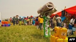 Des vendeurs arrivent pour participer à une foire organisée par des organisations internationales de secours pour tenter de relancer l'activité économique à Komanda, dans la province de l'Ituri le 27 janvier 2016. (Photo MARC JOURDIER / AFP)