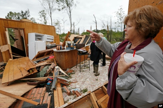 Freda Jenkins looks around the remains of a friend's damaged home, possibly by a tornado, April 19, 2019, in Morton, Miss.