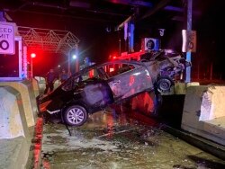 A car is jammed against a Maine Turnpike tollbooth, early Thursday, Sept. 23, 2021, in Falmouth, Maine, in a crash involving an an alleged drunken driver.