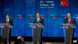 Turkish Prime Minister Ahmet Davutoglu (L), European Council President Donald Tusk (C) and European Commission President Jean-Claude Juncker address a media conference at an EU-Turkey summit on stemming the migrant flow into Europe, in Brussels, Nov. 29, 2015.