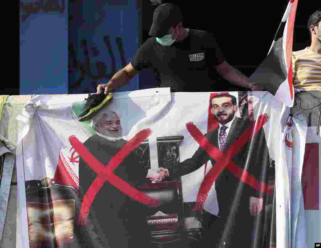 معترضان عراقی عکسی از دیدار رئیس مجلس این کشور با حسن روحانی را در دست دارند که بر روی چهره آنها ضربدر قرمز زده اند. معترضان عراقی به دخالت های جمهوری اسلامی اعتراض دارند.&nbsp;