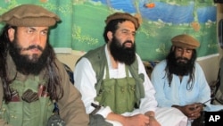 FILE - Pakistani Taliban spokesman Shahidullah Shahid (C), flanked by bodyguards, is seen talking to reporters at an undisclosed location in Pakistani tribal area of Waziristan, Oct. 5, 2013.