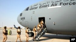 Qatari Air Force airmen board a Qatari transport plane evacuating people, at Hamid Karzai International Airport in Kabul, Afghanistan, August, 18, 2021. (Qatar Government Communications Office via AP)