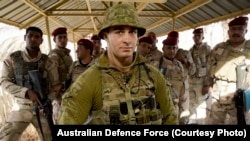 Serdadu AD Australia, Prajurit Dennis Lee, berdiri bersama dengan rekan-rekannya dari AD Irak saat memberikan perlindungan bagi pasukan di Komplek Militer Taji, Irak.