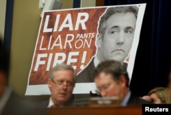 A sign reading "Liar Liar Pants on Fire!" is seen behind Rep. Mark Meadows (R-NC) and other Republican members of the committee during the testimony of former Trump personal attorney Michael Cohen at a House Committee on Oversight and Reform hearing on Capitol Hill, Feb. 27, 2019.