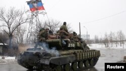 FILE - Troops from the separatist self-proclaimed Donetsk People's Republic drive an armored vehicle on the outskirts of Donetsk, Jan. 22, 2015.