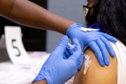 Seorang perempuan menerima vaksin COVID-19 di sebuah klinik di Philadelphia, Pennsylvania, AS, 18 Mei 2021. (Foto: REUTERS/Hannah Beier)