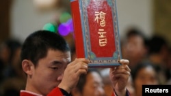 資料照：北京一家天主教堂在做聖誕彌撒時一名神職人員手舉聖經。 （2014年12月24日）