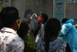 Seorang pekerja Kesehatan mengambil sampel untuk tes COVID-19 di Hyderabad, India, Senin, 3 Mei 2021. (Foto: Mahesh Kumar/AP)