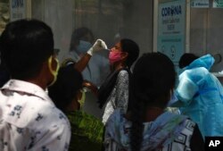 Zdravstveni radnik uzima bris nosa radi testiranja žene na COVID-19 u Hyderabadu, Indija, 3. maj 2021. (AP Photo / Mahesh Kumar A.)