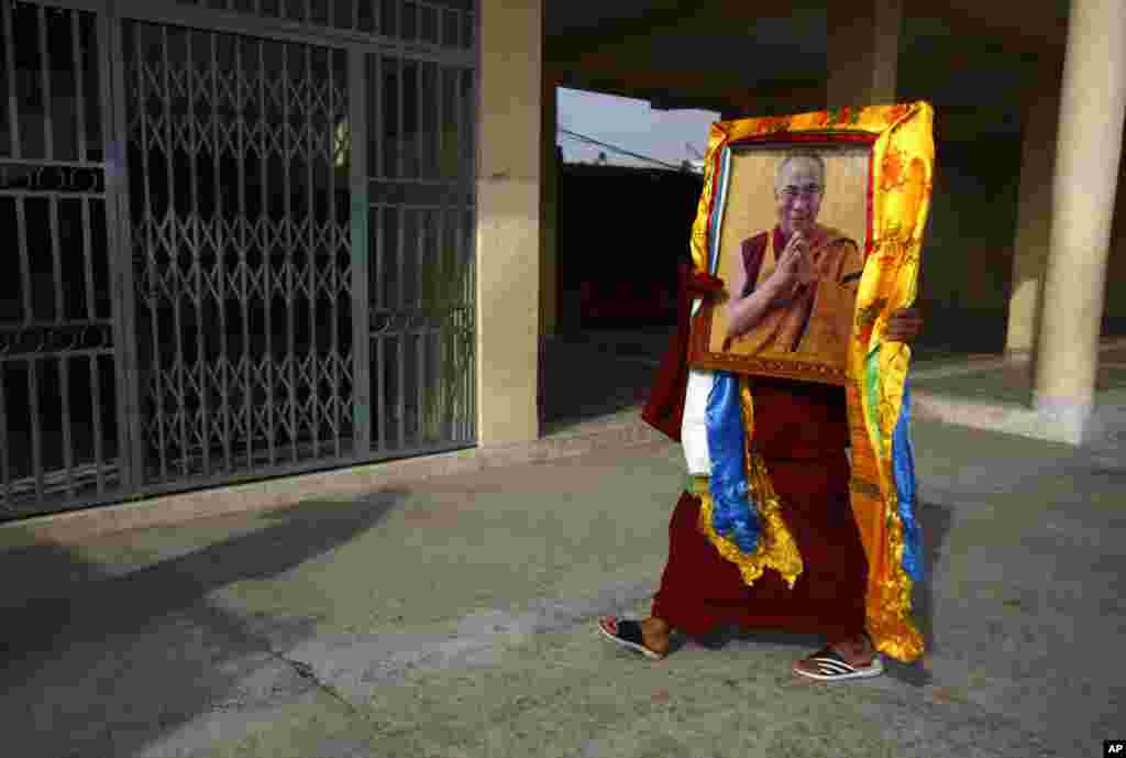 Biarawan Tibet membawa foto pemimpin spiritual Dalai Lama pada perayaan yang menandakan hari terakhir Tahun Baru Tibet atau Losar, di Kathmandu, Nepal.