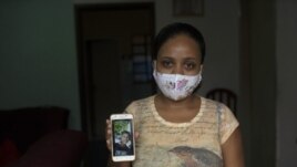 In this Monday, June 15, 2020 photo, Rafaela Matos shows a photo of her son João Pedro Matos Pinto, at her home in Sao Goncalo, Brazil. (AP Photo/Silvia Izquierdo)