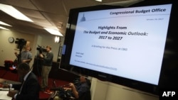 FILE - Members of the press cover a Congressional Budget Office (CBO) media briefing in Washington, D.C., Jan. 24, 2017.