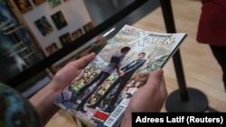 Seorang pelanggan memegang salinan Astonishing X-Men sambil mengantre untuk membeli buku komik di toko ritel buku komik di Manhattan, New York 20 Juni 2012. (Foto: Reuters/Adrees Latif)