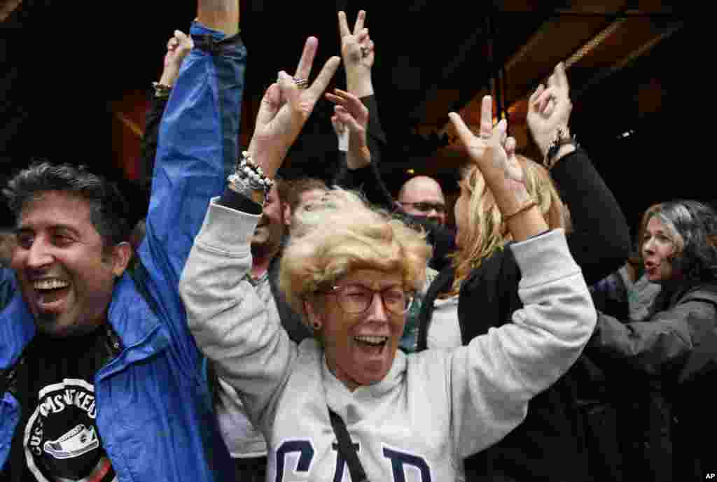 People cheer after voting at a school assigned to be a polling station by the Catalan government at the Gracia neighborhood in Barcelona, Spain, Oct. 1, 2017. 