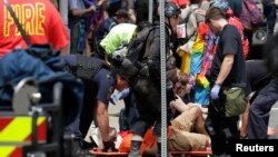救援人员帮助那些被汽车撞伤的人，他们是在维吉尼亚州夏洛特维尔市抗议白人至上主义者集会时被撞伤的。（2017年8月12日）