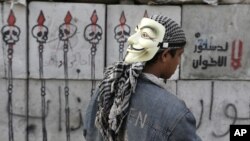 A protester looks at graffiti on cement blocks in front of the presidential palace in Cairo, Egypt, December 16, 2012. 