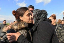 FILE- A relative kisses a Yazidi survivor woman following her release from Islamic State militants in Syria, in Duhok, Iraq, March 2, 2019.
