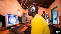 FILE - Young men surf the internet at a cyber cafe in Kibera slum in Nairobi, June 20, 2012.