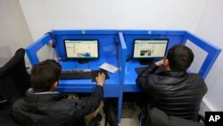 FILE - In this Feb. 10, 2016 photo, Afghans access social media websites at a private internet cafe in Kabul, Afghanistan.
