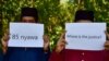 Community members hold up signs in front of a mass grave for victims of the Oct. 25, 2004, Tak Bai Massacre in which 85 Muslims died, most of them by suffocating in Thai army trucks, at a cemetery in Thailand's southern province of Narathiwat on Oct. 25, 2024.