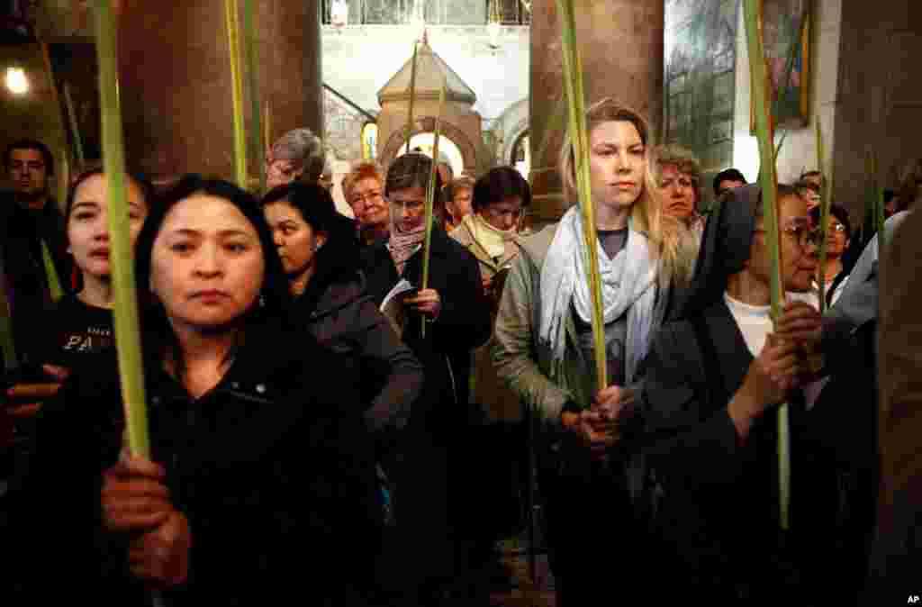 Christian pilgrims hold palm fronds during the Palm Sunday procession in the Church of the Holy Sepulcher, traditionally believed by many to be the site of the crucifixion, in Jerusalem&#39;s Old City.