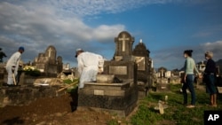 Familiares enterram parentes nu cemitário do Rio de Janeiro, 18 de Junho de 2021