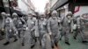 Army soldiers wearing protective suits spray disinfectant as a precaution against the new coronavirus at a shopping street in Seoul, South Korea.