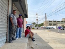 John Quintero (izq), venezolano consultado por la VOA, y sus amigos en una cola en estación de servicio en Maracaibo, estado Zulia, Venezuela. Abril, 2021. Foto: Gustavo Ocando.