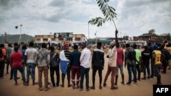 Les manifestants chantent l'hymne national congolais autour d'un rond-point à Beni lors d'une manifestation contre le report des élections sur le territoire des Beni et de la ville de Butembo le 27 décembre 2018.