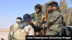 FILE - Afghan fighters with the Fatimiyoun Brigade in Syria.