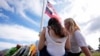 Two students view a memorial as the flags fly half-staff after a shooting Wednesday at Apalachee High School, Sept. 5, 2024, in Winder, Ga. 