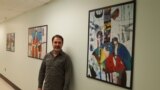 직장 복도에 걸어놓은 자신의 미술 작품들 앞에 선 루크만 아흐마드. 