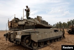 Izraelski vojnik se moli dok stoi na tenku, nedaleko od granice sa Pojasom Gaze, 9. oktobra 2023.