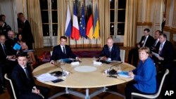 FILE - From left, Ukrainian President Volodymyr Zelenskiy, French President Emmanuel Macron, Russian President Vladimir Putin and German Chancellor Angela Merkel attend a working session in Paris, Dec. 9, 2019.